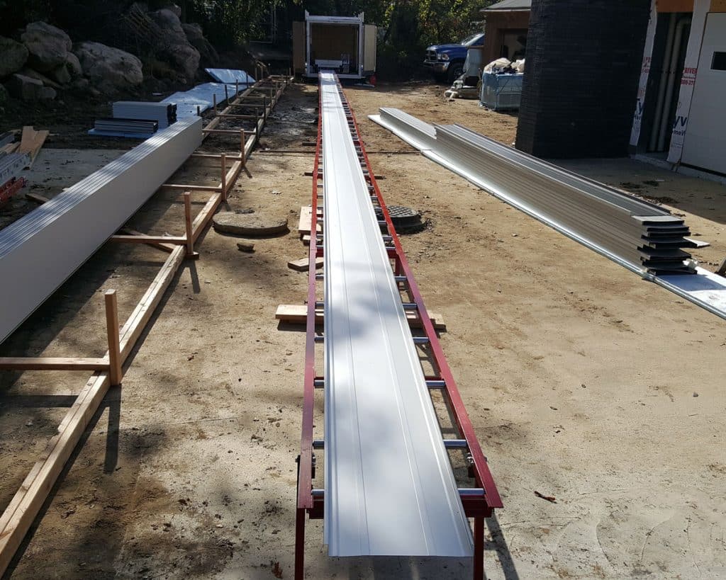 Long standing seam panel resting on support stands after roll forming