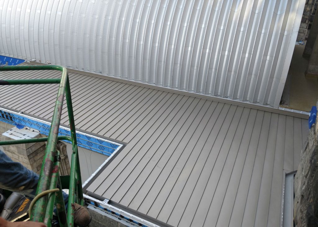 Standing seam roof edge and gutter seen from the scaffold
