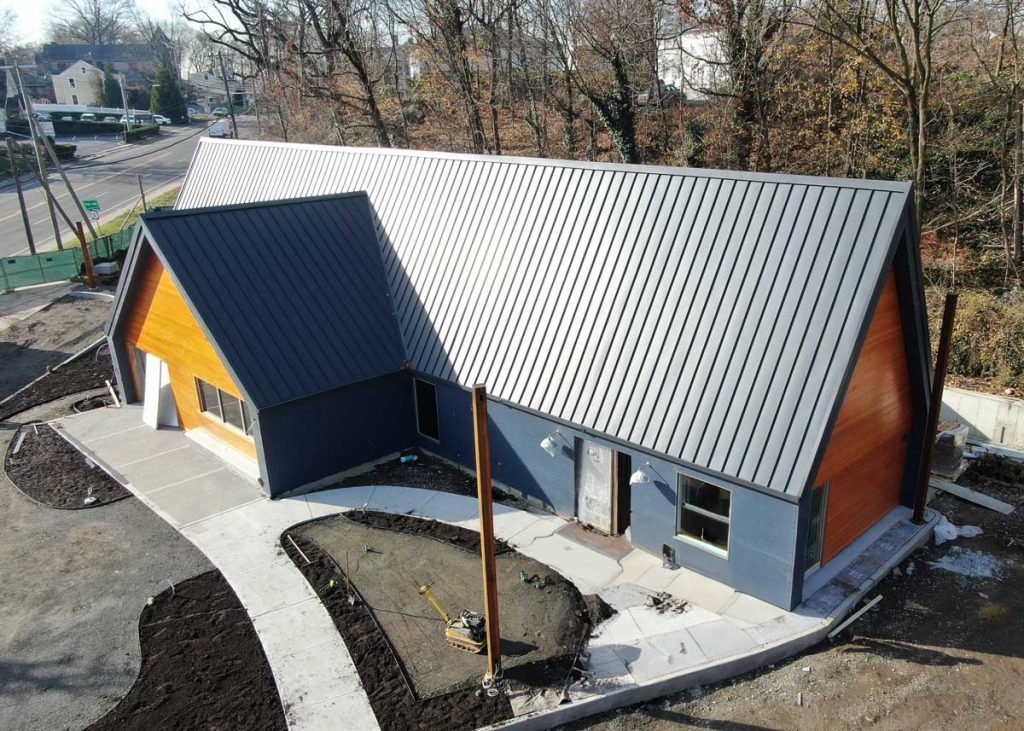 Aerial view of charcoal standing seam panels on a single-story building with wood gables