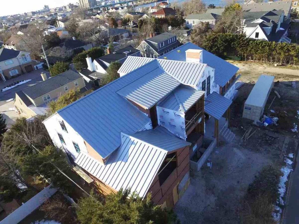Impact-Resistant Roof Insurance Discounts in Texas: What Carriers Offer and What to Ask Aerial view of a new two-story home with a silver standing seam roof