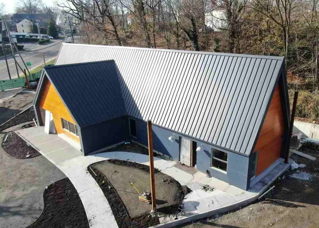 Tedlar PVF Film Dark standing seam metal roof on a single-story retail building with cedar gables