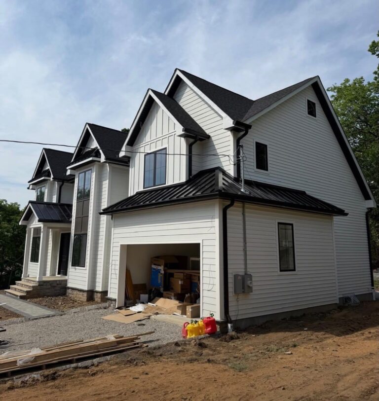 Hail Damage and Insurance Claims White two-story home with a black standing seam hip roof over the attached garage