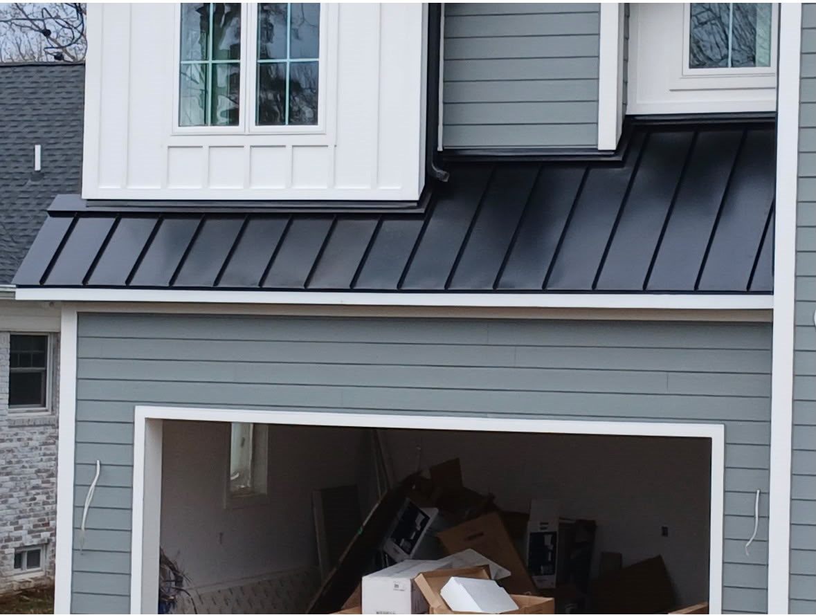 Black Standing Seam Garage and Porch Roofs on a Gray Home Black standing seam garage roof stepping around a dormer