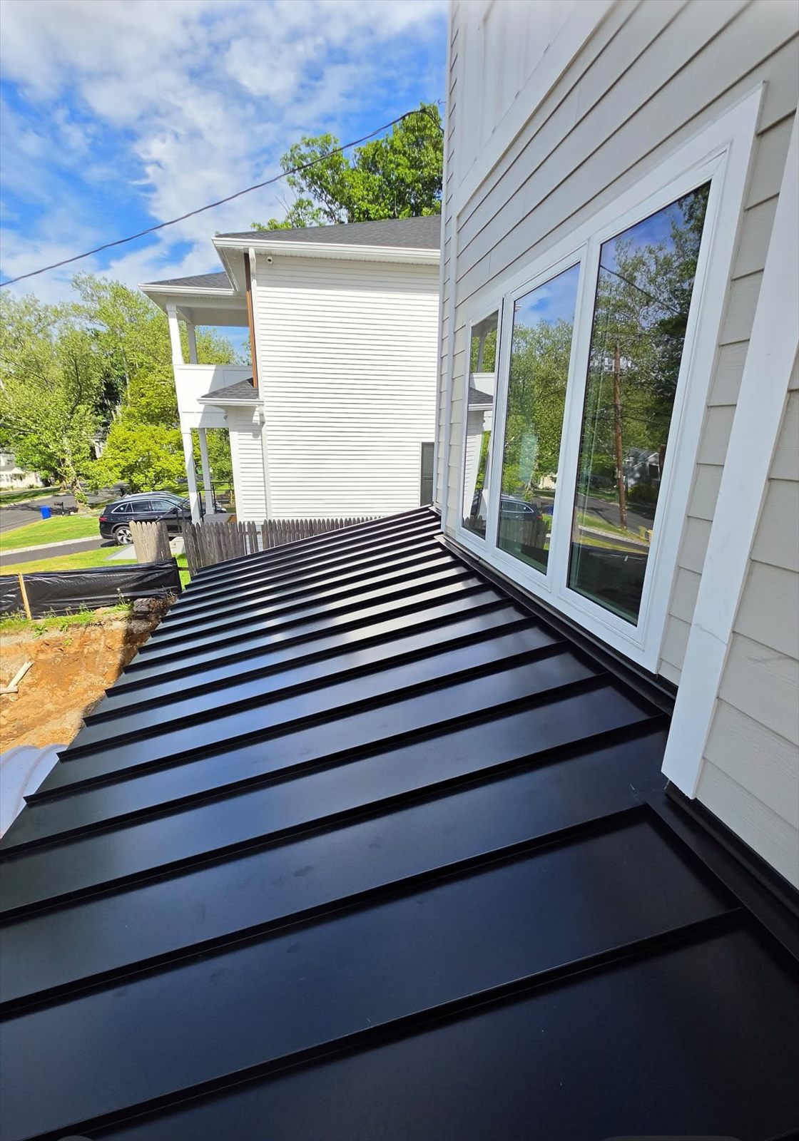 Services Standing seam roof meeting a wall with flashing below the windows