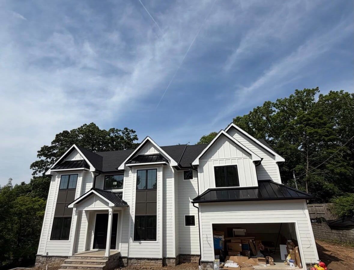 Black Standing Seam Accent Roofs on a Large White Home Large white home with black standing seam roofs over the porch, bays and garage
